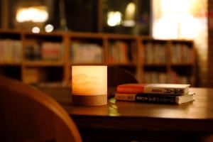 una pila di libri seduti su un tavolo in una biblioteca di Hotel OBANA a Nara