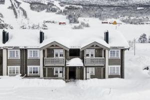 ein Haus mit Schnee auf dem Dach in der Unterkunft BjorliKos in Bjorli