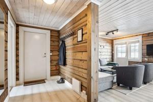uma sala de estar com paredes de madeira e uma porta em BjorliKos em Bjorli