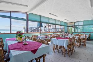 Pansion Adria Haus في بوسيدارجي: غرفة طعام مع طاولات وكراسي ونوافذ