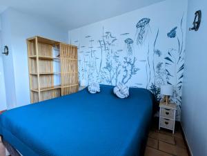 a bedroom with a blue bed and a mural of plants at La villa Acacia in Coti-Chiavari