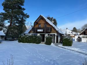 een huis met sneeuw op de grond ervoor bij Ferienhaus am Silbersee 86 in Frielendorf