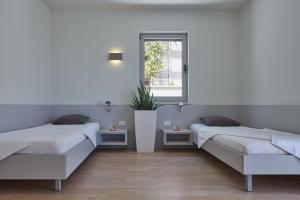 two beds in a room with a window at Villa Roca in Vis