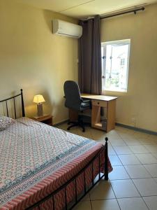 een slaapkamer met een bed, een bureau en een raam bij Cyber Village Topaz 502 in Ebene