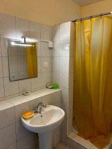een badkamer met een wastafel en een geel douchegordijn bij Cyber Village Topaz 502 in Ebene