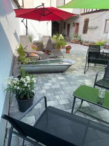 une terrasse avec des chaises, une table et un parasol dans l'établissement Haus Gaui, à Kirrweiler