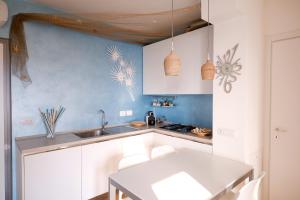 GARDA BLUE HOME on the lake - pool, solarium and garage في توسكولانو ماديرنو: مطبخ مع مغسلة وطاولة بيضاء +37 صورة