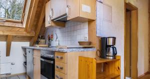 uma pequena cozinha com armários de madeira e um fogão em Ferienwohnung Pfisterhof em Kirchzarten