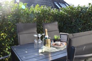 Una mesa con una botella de champán. en Ferienhaus am Silbersee 86, en Frielendorf