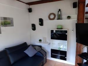 ein Wohnzimmer mit einem Sofa und einem TV in der Unterkunft Ferienhaus am Silbersee 86 in Frielendorf