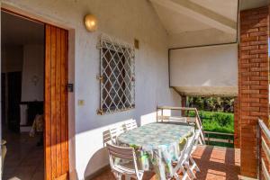 una mesa y sillas en el porche de una casa en Casa marina Ampio - Castiglione, en Castiglione della Pescaia