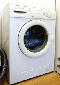 eine weiße Waschmaschine in einem Zimmer in der Unterkunft GARDA BLUE HOME - Piscina, Solarium e Box in Toscolano-Maderno