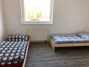 2 camas en una habitación con ventana en UBYTOVNA SK Posázavan Poříčí nad Sázavou, en Poříčí nad Sázavou