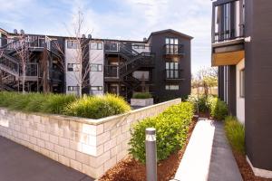 an apartment building with a retaining wall and plants at Penthouse Apartment Scenic Views-Spacious 2br in Christchurch