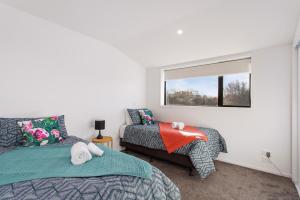a bedroom with two beds and a window at Penthouse Apartment Scenic Views-Spacious 2br in Christchurch