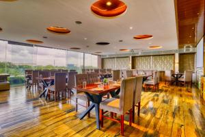 a restaurant with wooden floors and tables and chairs at The Ashoka Hotel, Vijay Nagar in Indore