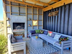 a screened in porch with couches and a fireplace at Slow Track Farm in Baardskeerdersbos