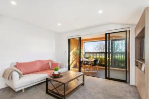 a living room with a couch and a table at Penthouse Apartment Scenic Views-Spacious 2br in Christchurch