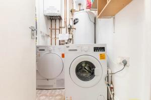 a washer and dryer in a laundry room at Deluxe Ensuite Central Cov in Coventry