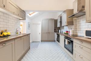 a large kitchen with white appliances and white tiles at Deluxe Ensuite Central Cov #6 in Coventry