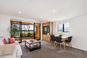 a living room with a couch and a table at Penthouse Apartment Scenic Views-Spacious 2br in Christchurch