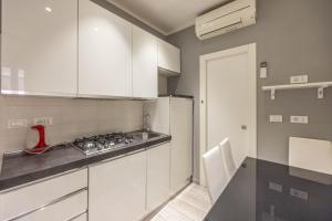 una cucina con mobili bianchi e un piano di lavoro di De'Giudei, Bologna by Short Holidays a Bologna Altre 15 foto