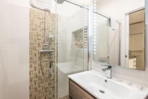 un bagno bianco con lavandino e doccia di De'Giudei, Bologna by Short Holidays a Bologna