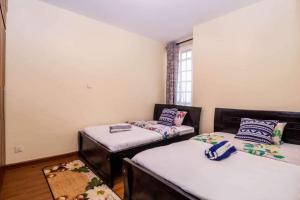 Habitación con 2 camas individuales y ventana. en JCA APARTMENTS, en Nairobi
