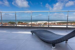 a bench on top of a building with a view of the ocean at Océane Bed and Breakfast in Nazaré