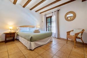 um quarto com uma cama, uma cadeira e uma janela em Casa Entera Cal Tous em Rojals