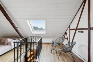 Habitación con escalera, sillas y sofá en Stylish & Relaxing Penthouse ~ Workspace ~ Parking en Gelsenkirchen