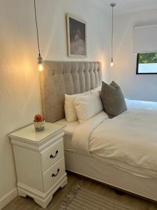 een slaapkamer met een wit bed en een nachtkastje bij Comfort Zone in Johannesburg