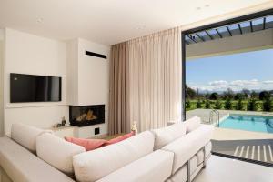 a living room with a white couch and a tv at Ioannina Secret Luxury Villas in Ioannina