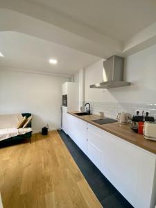 uma cozinha com armários brancos e piso em madeira em Paris - Notre Dame - Panthéon - Luxembourg - 30 m2 em Paris