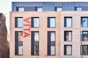 un edificio de ladrillo con flechas rojas. en ALTIDO Aparthotel at Vita Iona Street - Adults only en Edimburgo