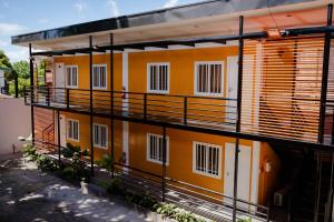 an orange and white building with a lot of windows at Balay Talisay 