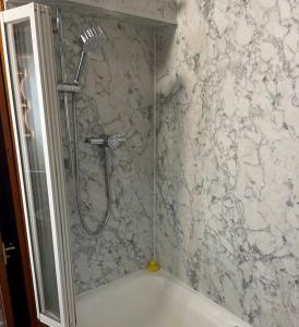La salle de bains est pourvue d'une douche et d'un mur en marbre. dans l'établissement Twattleton Cottage Kilburn Yorkshire - Beautiful views, à York