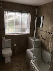 a bathroom with a toilet and a tub and a sink at Seaview Cottage in Bacton