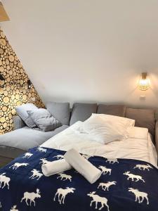 a bed with a blue blanket with white horses on it at Domek Tatry - Stacja Wierchowa 972 m in Brzegi