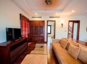 a living room with a couch and a flat screen tv at 3BR garden pool villas in beach resort in Da Nang