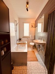 een badkamer met een bad, een toilet en een wastafel bij Moderne Ferienwohnung Iserlohn in Iserlohn