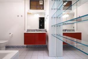 a bathroom with red and white walls and glass shelves at HomNest I S.Ambrogio Elegant Apt in Milan