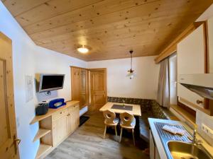 cocina con techos de madera, escritorio y sillas en Apartment Seespitz, en Längenfeld