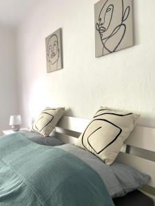 a bedroom with two beds and two pictures on the wall at Allegra Appartements in Nohfelden