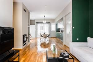 a living room with a white couch and a green wall at The Gate by Zoia Living in Athens