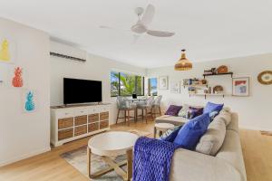 a living room with a couch and a tv at Bilinga Bliss - Luxury beachfront apartment in Gold Coast