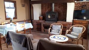 a living room with a fireplace and a table and chairs at La Commère: Gîte dans un cadre champêtre 