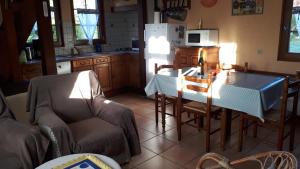 a kitchen with a table and chairs and a refrigerator at La Commère: Gîte dans un cadre champêtre 