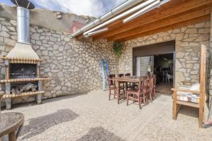 un patio con chimenea, mesa y sillas en El Petit Maialenc, en Mayals