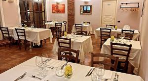 un restaurant avec tables et chaises et nappes blanches dans l'établissement CASCINA DOMINA, à Gassino Torinese